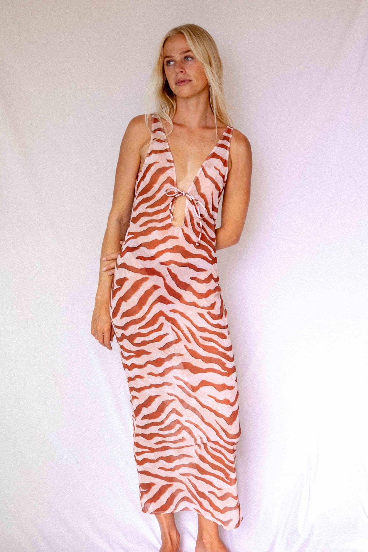 Maxi Dress in Dune animal print, front three-quarter view showing deep V-neckline, front tie detail, and flowing length
