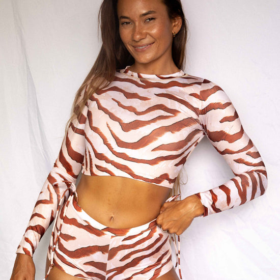 Lola Low-Rise Surf Shorts in Dune animal print, front smiling view worn with matching Lola rashguard, women's surf set by Antidote The Label