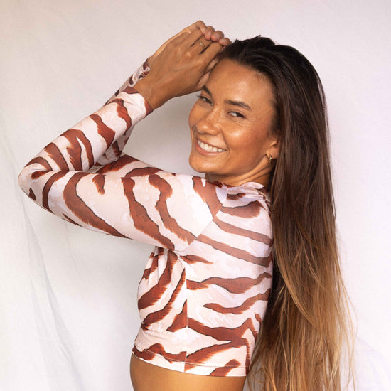 Lola Long-Sleeve Surf Rashguard in Dune animal print, three-quarter back view showing mock neck and long sleeve construction