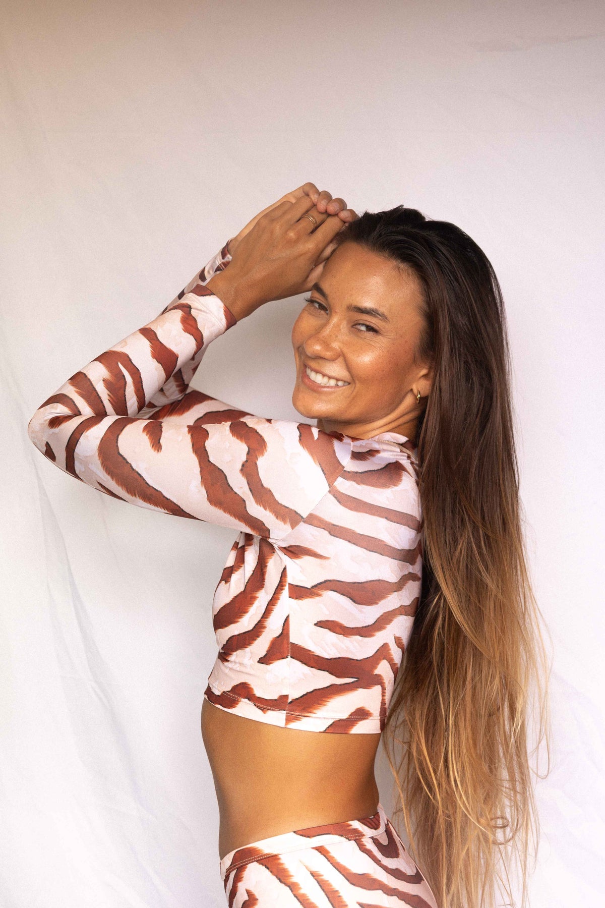 Lola Long-Sleeve Surf Rashguard in Dune animal print, three-quarter back view showing mock neck and long sleeve construction
