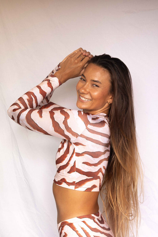 Lola Long-Sleeve Surf Rashguard in Dune animal print, three-quarter back view showing mock neck and long sleeve construction