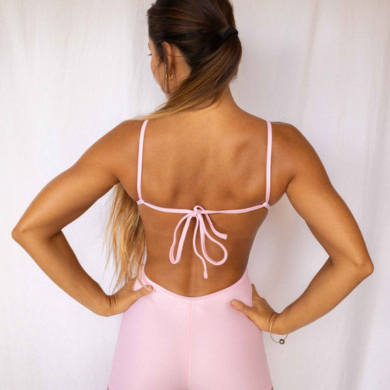 Elle Surf Suit in Blush — back view showing open back with adjustable tie detail and fitted boyshort silhouette