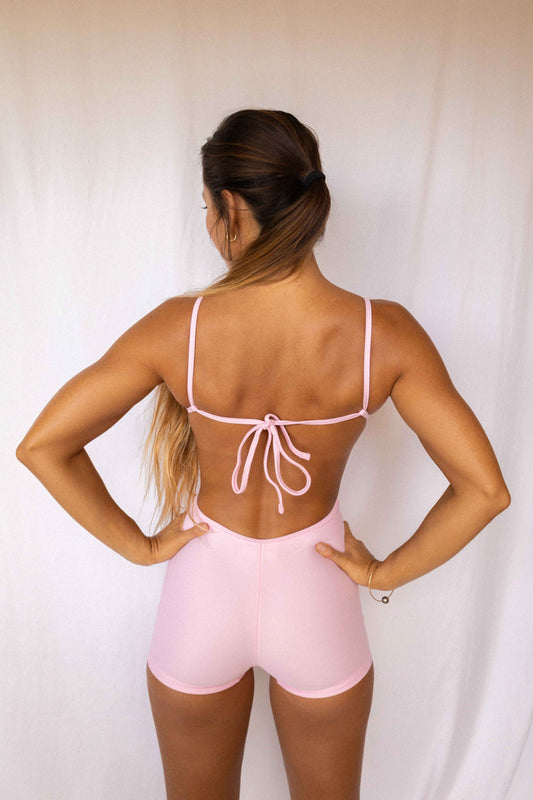 Elle Surf Suit in Blush — back view showing open back with adjustable tie detail and fitted boyshort silhouette