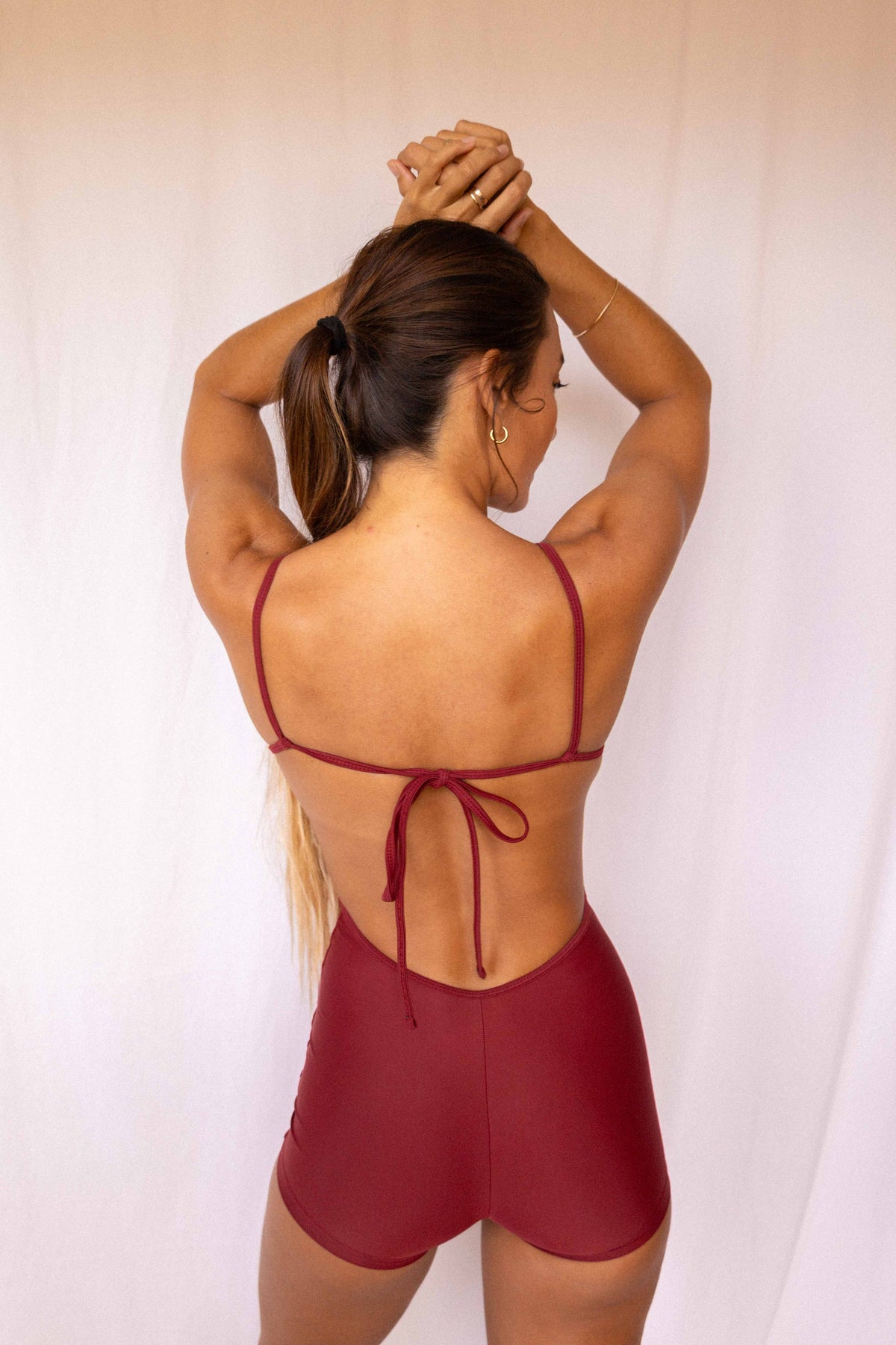 Elle Surf Suit in Deep Merlot — back view showing open back with adjustable tie detail and short cut, Antidote The Label