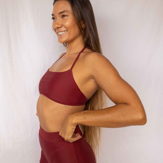 Niki Surf Top and Shorts set in Deep Merlot, smiling side profile view showing thin strap top and high-waist shorts by Antidote The Label