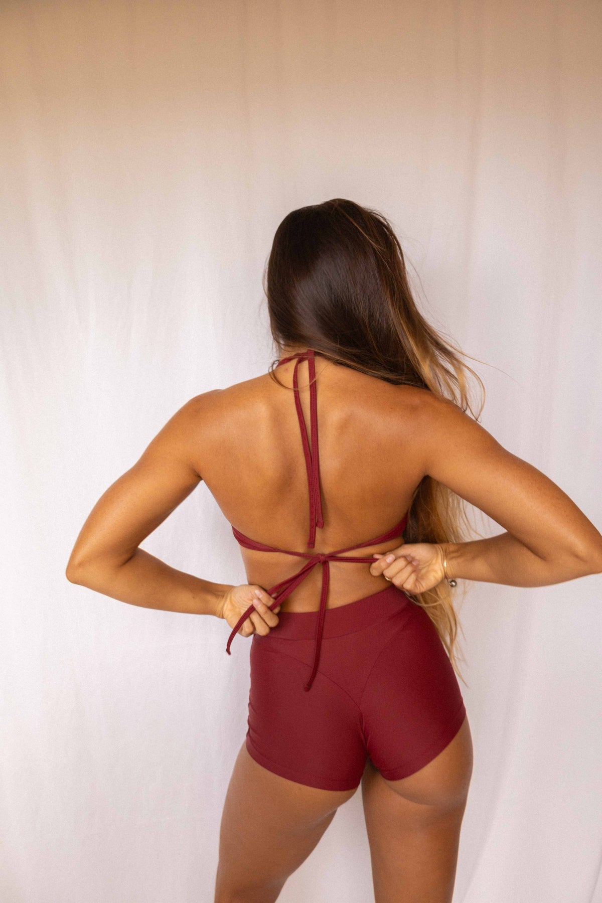 Niki Surf Top and Shorts set in Deep Merlot, full back view showing crossback tie straps and high-waist short construction
