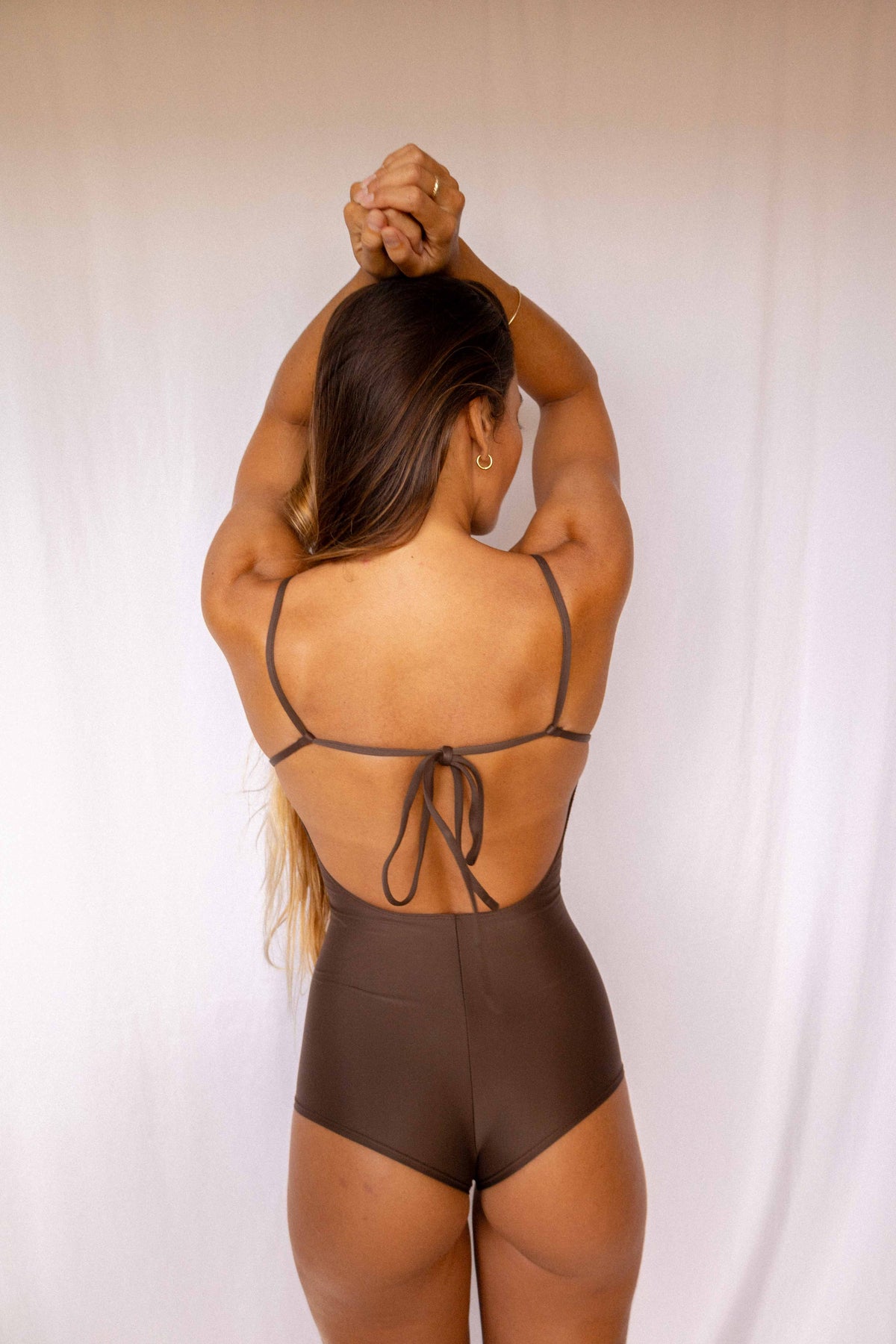 Emi Surf Suit in Coffee — back view showing open back with adjustable tie detail and high-waist coverage
