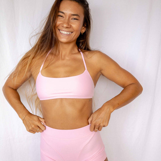 Niki Surf Top and Shorts set in Blush, smiling full front view showing halter neckline, cropped top, and high-waist short silhouette by Antidote The Label