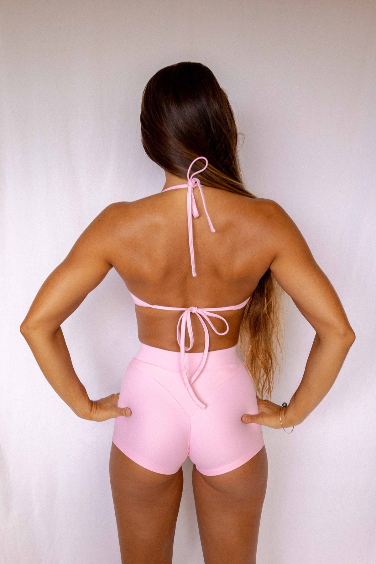 Niki Surf Top in Blush, full back view showing halter neck tie and lower back tie detail worn with matching Niki surf shorts