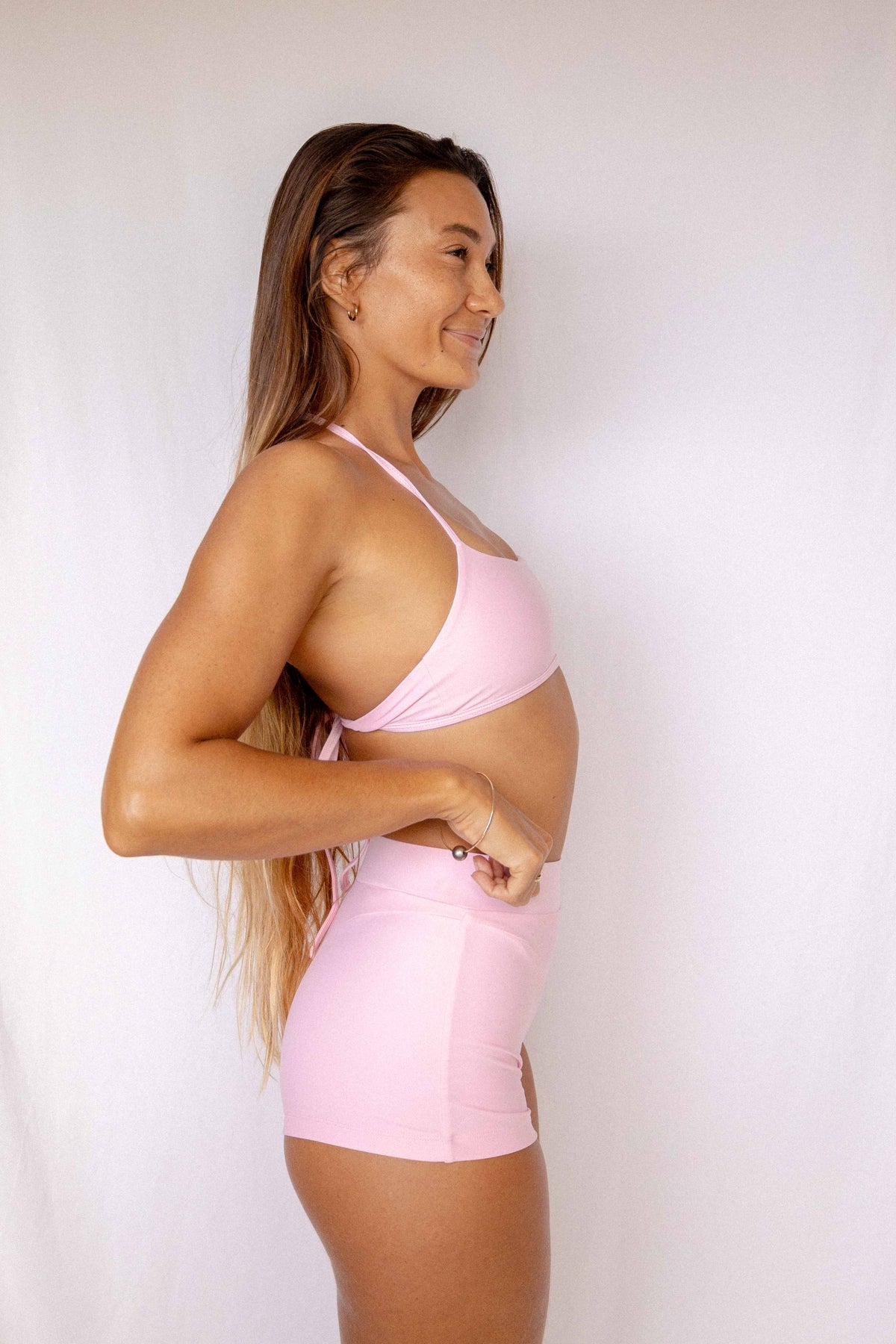 Niki Surf Top and Shorts set in Blush, smiling side profile view showing halter top construction and high-waist short fit by Antidote The Label
