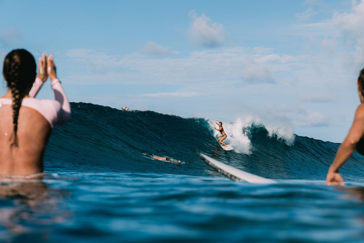 Ona Surf Top and bottoms in Deep Merlot worn surfing in ocean waves with tropical backdrop, women's performance surf top by Antidote The Label