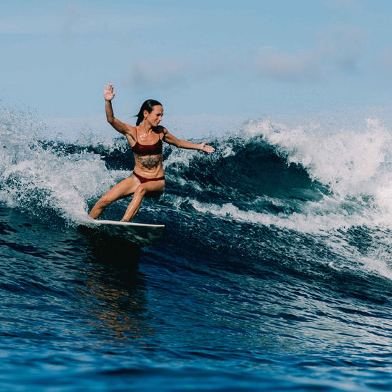 Ona surf bikini set in Deep Merlot worn surfing a wave, women's performance surf bikini by Antidote The Label